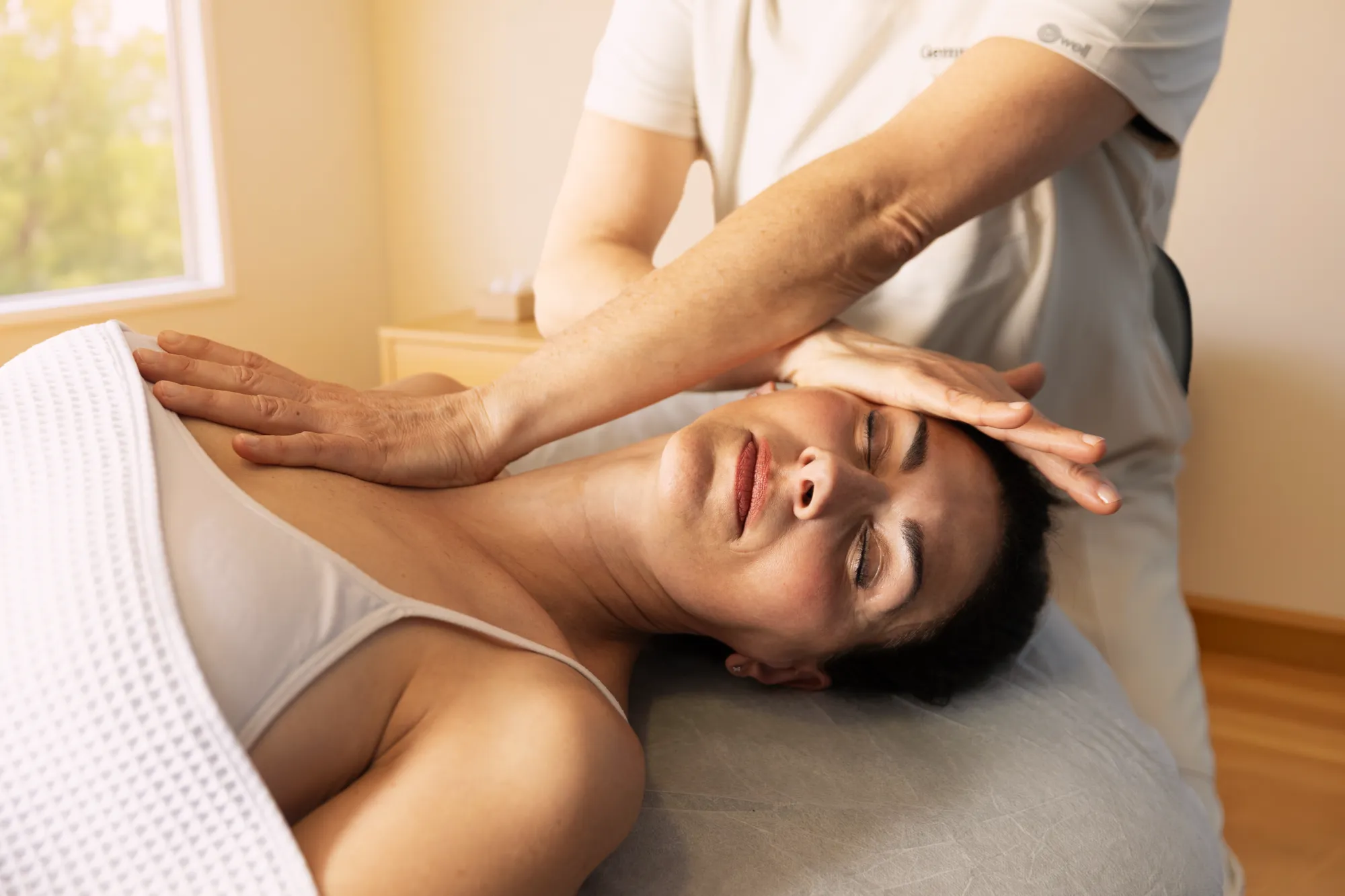 Gemma Fernández performing a manual physical therapy technique on a patient's neck and head.
