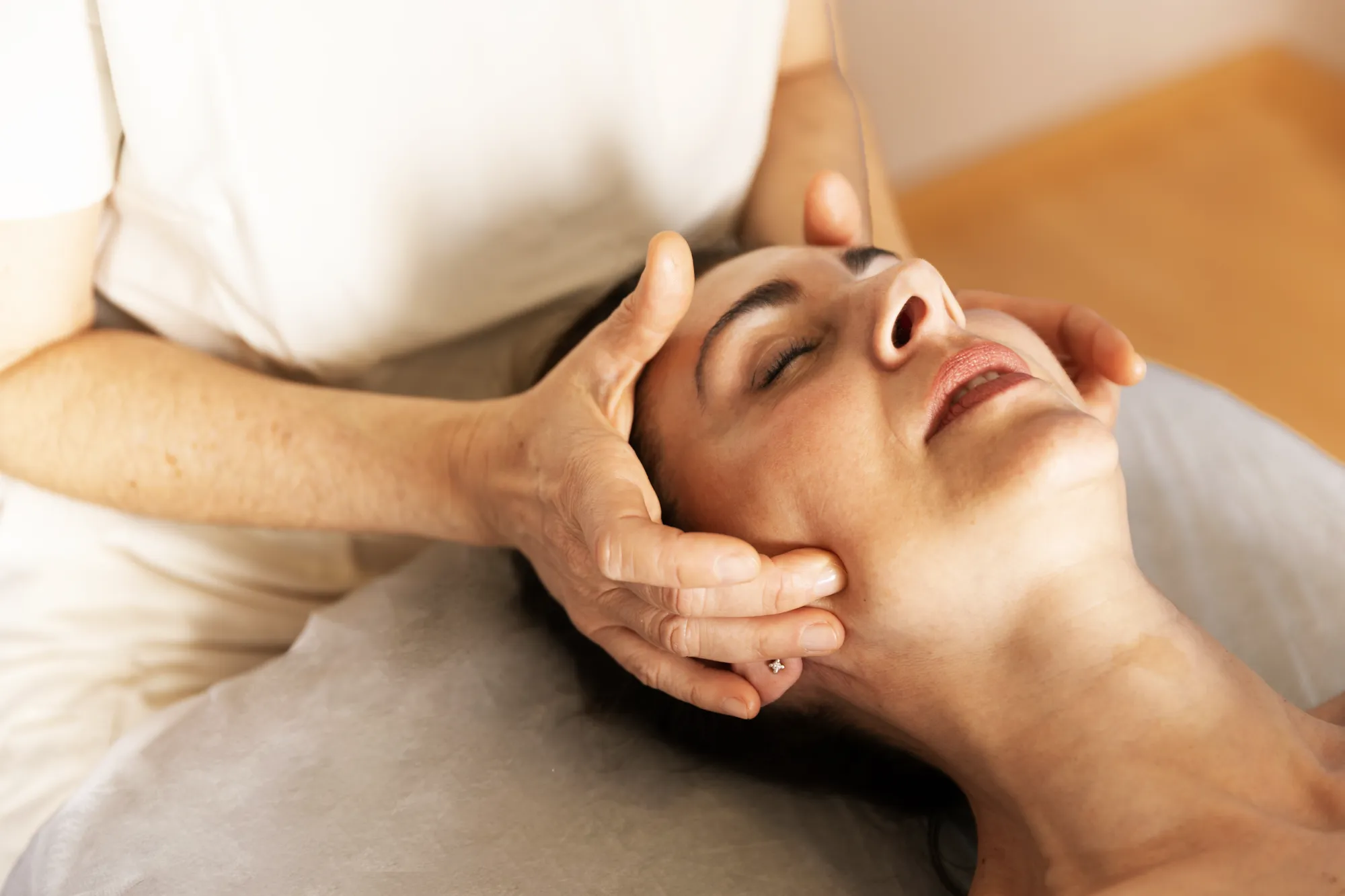 A close-up of a therapeutic facial massage performed by physical therapist Gemma Fernández.