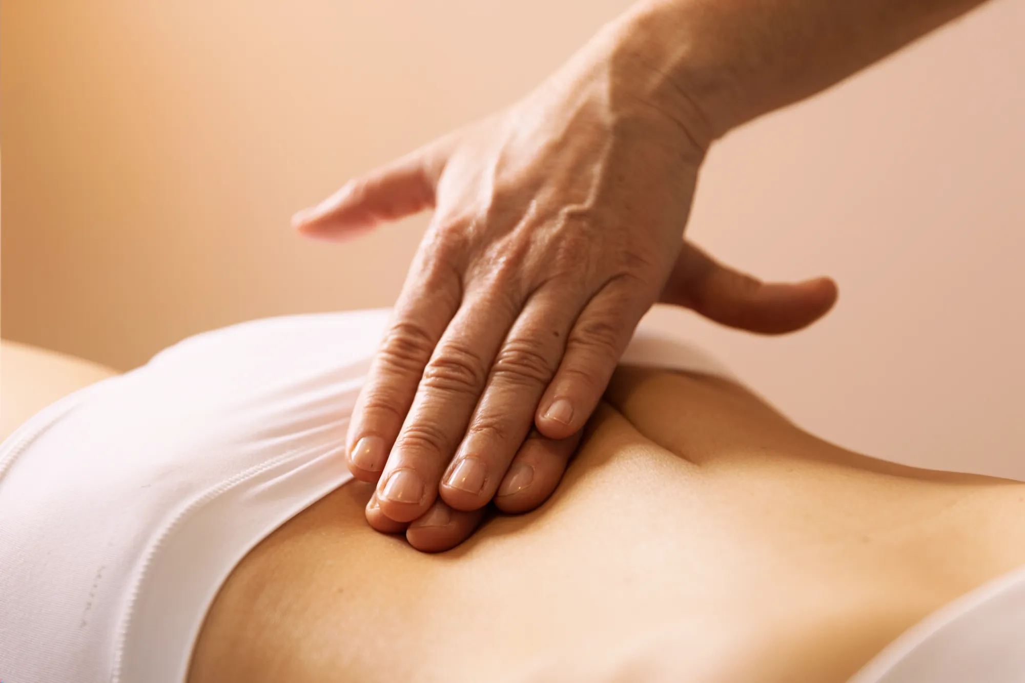 Primer plano de técnica de drenaje linfático manual aplicada en el abdomen de una paciente.