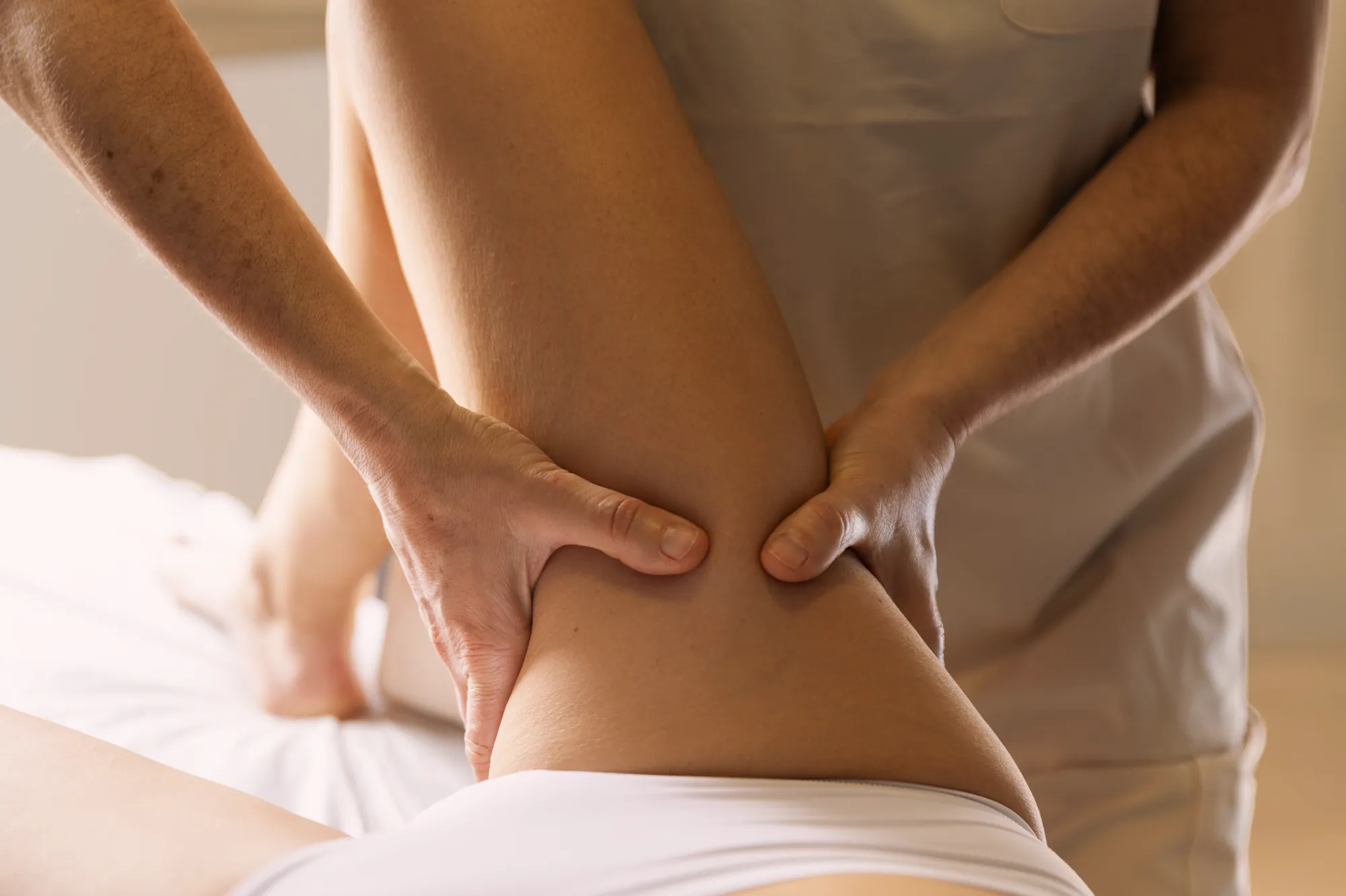 Gemma Fernández performing manual lymphatic drainage on a patient's thigh.